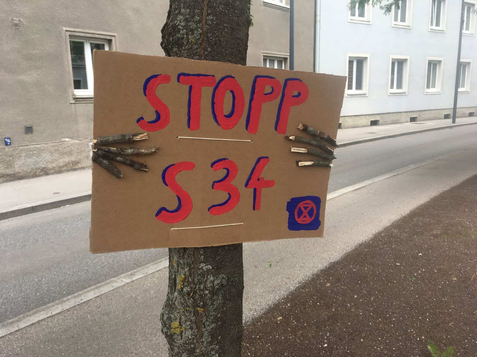 in Baum hält ein Schild und demonstriert gegen die S34 (Akion #aufbäumen)