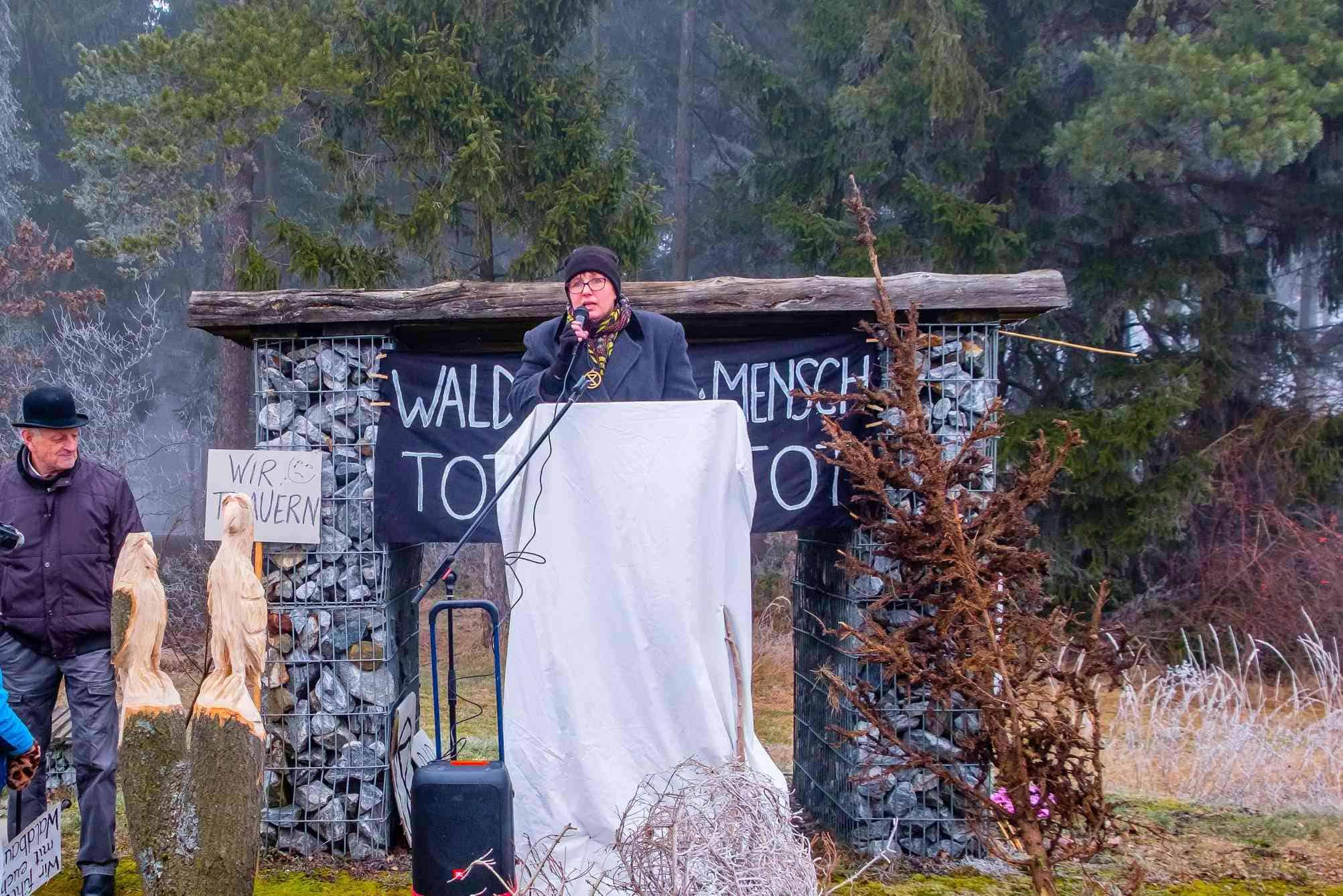 Eine Aktivistin hält eine Rede beim "Trauermarsch" für den Wald
